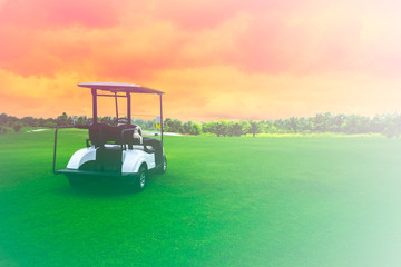 Golf cart car in fairway of golf course with fresh green grass field and cloud sky and tree on sunset time - 302863755
