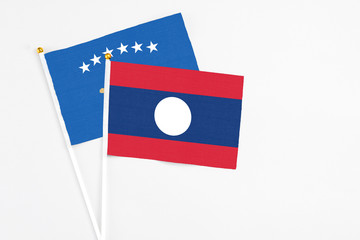 Laos and Kosovo stick flags on white background. High quality fabric, miniature national flag. Peaceful global concept.White floor for copy space.