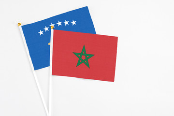 Morocco and Kosovo stick flags on white background. High quality fabric, miniature national flag. Peaceful global concept.White floor for copy space.