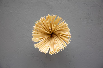 Uncooked dry white Ramen noodles over gray background, top view. From above, overhead.