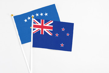 Fototapeta premium New Zealand and Kosovo stick flags on white background. High quality fabric, miniature national flag. Peaceful global concept.White floor for copy space.