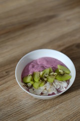 berry smoothie bowl with kiwi and coconut slices