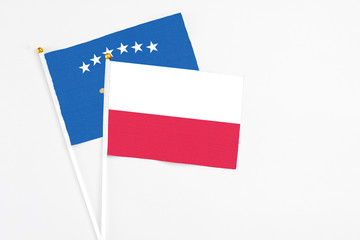 Poland and Kosovo stick flags on white background. High quality fabric, miniature national flag. Peaceful global concept.White floor for copy space.