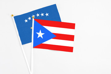 Puerto Rico and Kosovo stick flags on white background. High quality fabric, miniature national flag. Peaceful global concept.White floor for copy space.