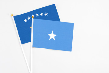 Somalia and Kosovo stick flags on white background. High quality fabric, miniature national flag. Peaceful global concept.White floor for copy space.