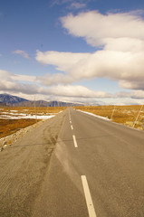 Naklejka premium Endlose Straße in Norwegischer Gebirgslandschaft mit Schnee