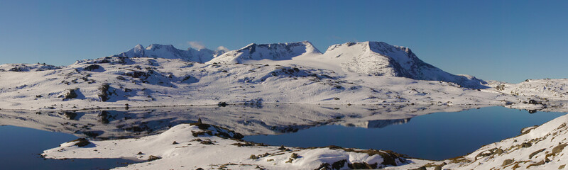 Klarer See in Schneebedeckte Gebirgslandschaft in Norwegen Panorama