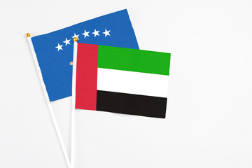 United Arab Emirates and Kosovo stick flags on white background. High quality fabric, miniature national flag. Peaceful global concept.White floor for copy space.