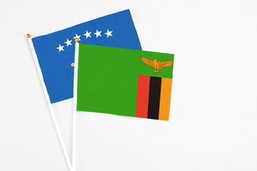 Zambia and Kosovo stick flags on white background. High quality fabric, miniature national flag. Peaceful global concept.White floor for copy space.