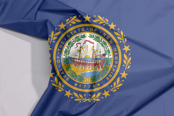 New Hampshire fabric flag crepe and crease with white space, the states of America. The State Seal of New Hampshire on a blue field.