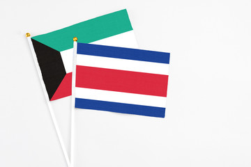 Costa Rica and Kuwait stick flags on white background. High quality fabric, miniature national flag. Peaceful global concept.White floor for copy space.
