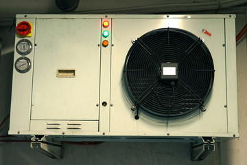 Compact outdoor refrigeration unit with fan used to serve cooling showcase or box.