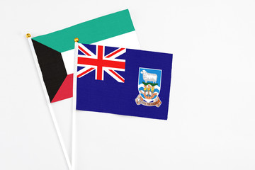 Falkland Islands and Kuwait stick flags on white background. High quality fabric, miniature national flag. Peaceful global concept.White floor for copy space.