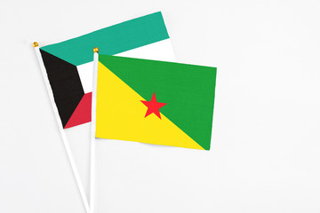 French Guiana and Kuwait stick flags on white background. High quality fabric, miniature national flag. Peaceful global concept.White floor for copy space.