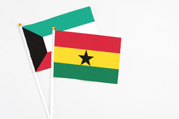 Ghana and Kuwait stick flags on white background. High quality fabric, miniature national flag. Peaceful global concept.White floor for copy space.