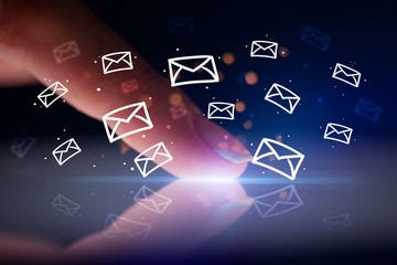 Finger touching tablet with white drawn mail icons above and dark background