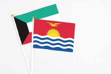 Kiribati and Kuwait stick flags on white background. High quality fabric, miniature national flag. Peaceful global concept.White floor for copy space.
