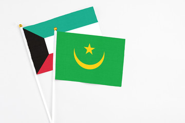 Mauritania and Kuwait stick flags on white background. High quality fabric, miniature national flag. Peaceful global concept.White floor for copy space.