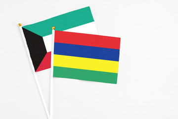 Mauritius and Kuwait stick flags on white background. High quality fabric, miniature national flag. Peaceful global concept.White floor for copy space.
