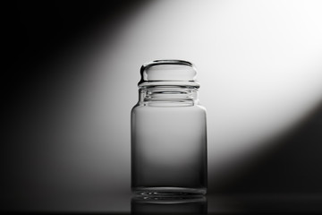 Empty glass jar on a black and white background