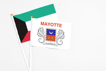 Mayotte and Kuwait stick flags on white background. High quality fabric, miniature national flag. Peaceful global concept.White floor for copy space.