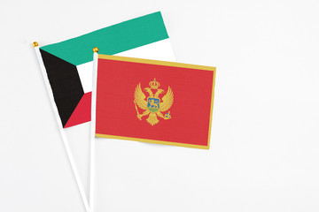 Montenegro and Kuwait stick flags on white background. High quality fabric, miniature national flag. Peaceful global concept.White floor for copy space.