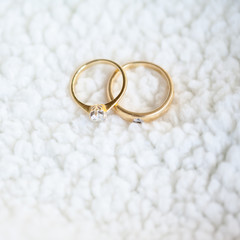 Obraz na płótnie Canvas Diamond wedding rings on white soft wool