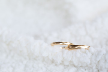 Golden wedding rings on white soft wool