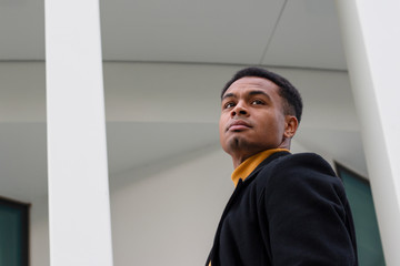 Student steht vor der Universit&auml;t und sieht nach hinten