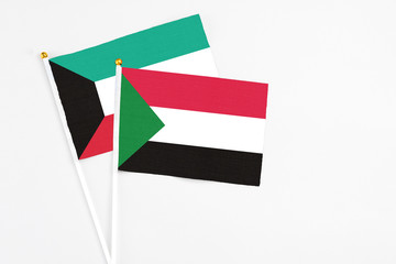Sudan and Kuwait stick flags on white background. High quality fabric, miniature national flag. Peaceful global concept.White floor for copy space.