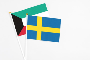 Sweden and Kuwait stick flags on white background. High quality fabric, miniature national flag. Peaceful global concept.White floor for copy space.
