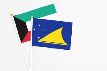 Tokelau and Kuwait stick flags on white background. High quality fabric, miniature national flag. Peaceful global concept.White floor for copy space.