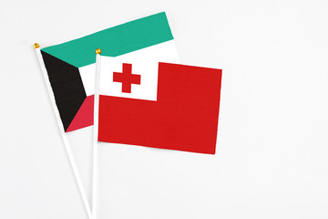 Obraz premium Tonga and Kuwait stick flags on white background. High quality fabric, miniature national flag. Peaceful global concept.White floor for copy space.