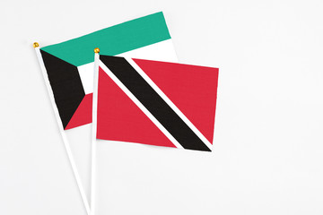 Trinidad And Tobago and Kuwait stick flags on white background. High quality fabric, miniature national flag. Peaceful global concept.White floor for copy space.