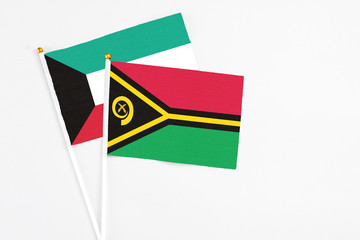 Vanuatu and Kuwait stick flags on white background. High quality fabric, miniature national flag. Peaceful global concept.White floor for copy space.