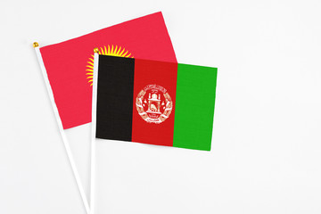 Afghanistan and Kyrgyzstan stick flags on white background. High quality fabric, miniature national flag. Peaceful global concept.White floor for copy space.