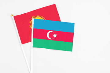Azerbaijan and Kyrgyzstan stick flags on white background. High quality fabric, miniature national flag. Peaceful global concept.White floor for copy space.
