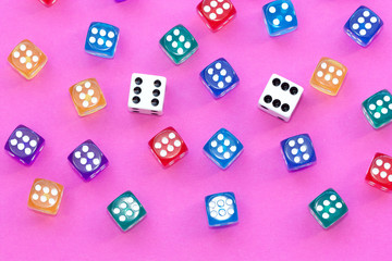 Gambling dices on a pink background.