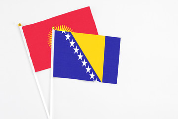 Bosnia Herzegovina and Kyrgyzstan stick flags on white background. High quality fabric, miniature...