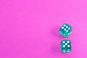 Gambling dices on a pink background.