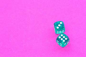 Gambling dices on a pink background.