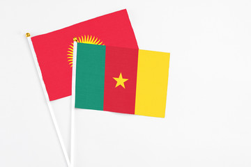 Cameroon and Kyrgyzstan stick flags on white background. High quality fabric, miniature national flag. Peaceful global concept.White floor for copy space.