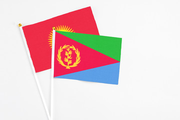 Eritrea and Kyrgyzstan stick flags on white background. High quality fabric, miniature national flag. Peaceful global concept.White floor for copy space.