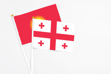 Georgia and Kyrgyzstan stick flags on white background. High quality fabric, miniature national flag. Peaceful global concept.White floor for copy space.