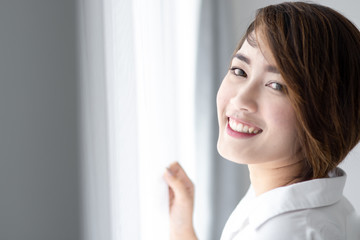 Beautiful woman with white curtain with natural light.