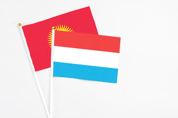 Luxembourg and Kyrgyzstan stick flags on white background. High quality fabric, miniature national flag. Peaceful global concept.White floor for copy space.