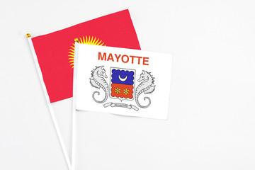 Mayotte and Kyrgyzstan stick flags on white background. High quality fabric, miniature national flag. Peaceful global concept.White floor for copy space.