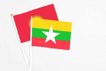 Myanmar and Kyrgyzstan stick flags on white background. High quality fabric, miniature national flag. Peaceful global concept.White floor for copy space.