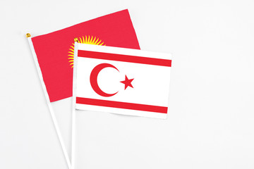 Northern Cyprus and Kyrgyzstan stick flags on white background. High quality fabric, miniature national flag. Peaceful global concept.White floor for copy space.