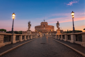 Fototapeta na wymiar Ponte Sant'Angelo at dawn with Castel Sant'Angelo in background. Castel Santangelo fortress and bridge view in Rome, Italy. Saint Angel Castle with Tiber river in Rome, Italy at sunrise.